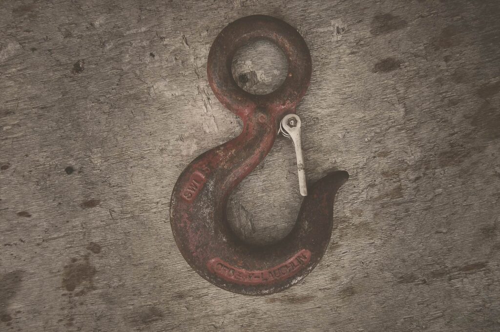 Crane hook on a wooden background.