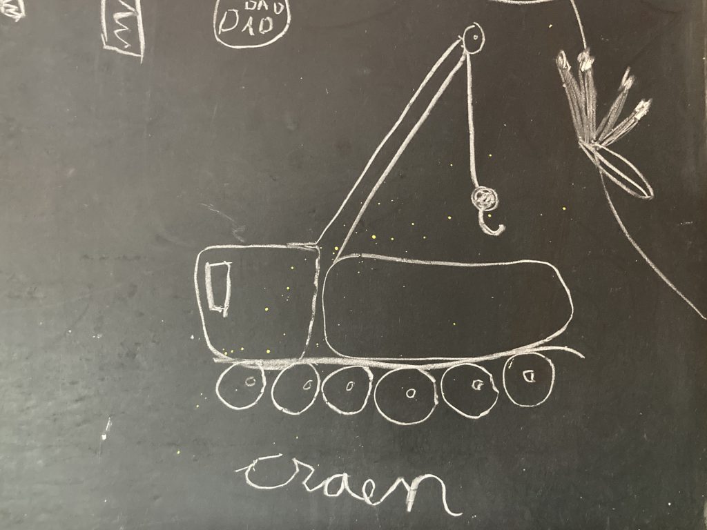 A child's drawing of a crane on chalkboard.